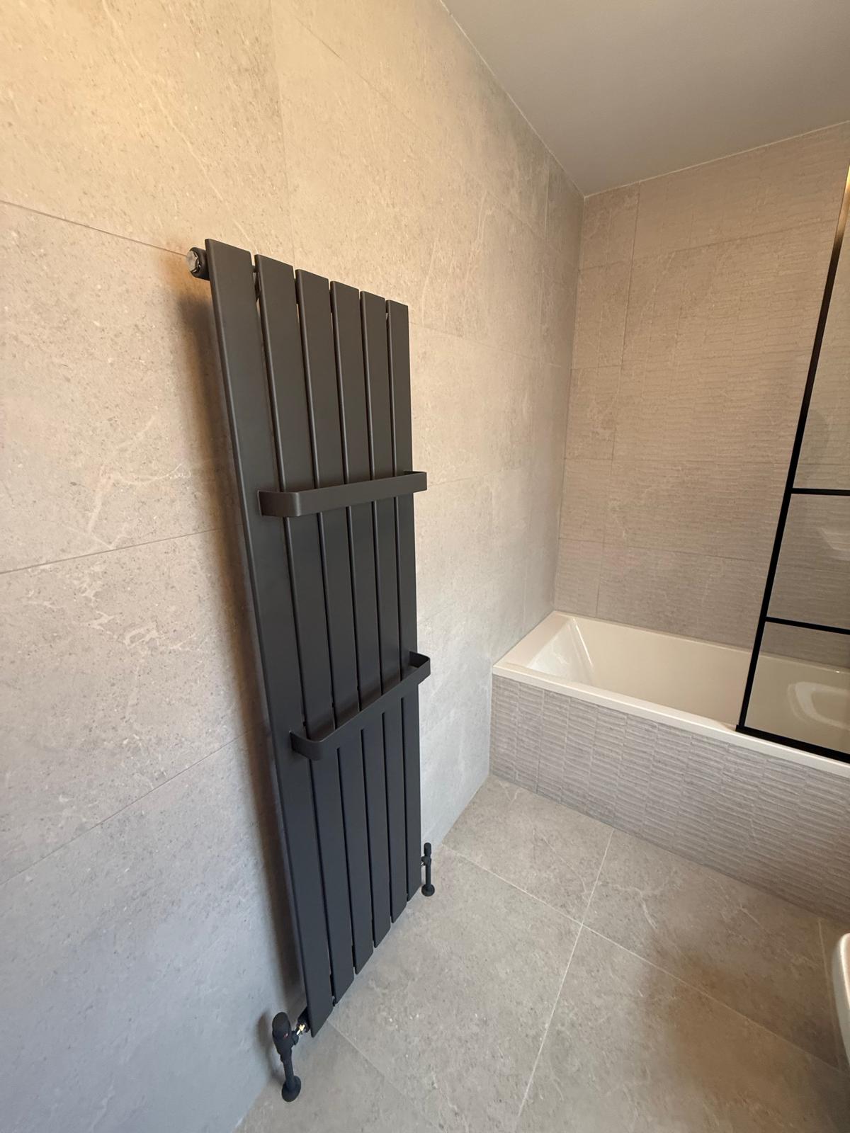 Finished bathroom with stone-look tiling and dark fittings