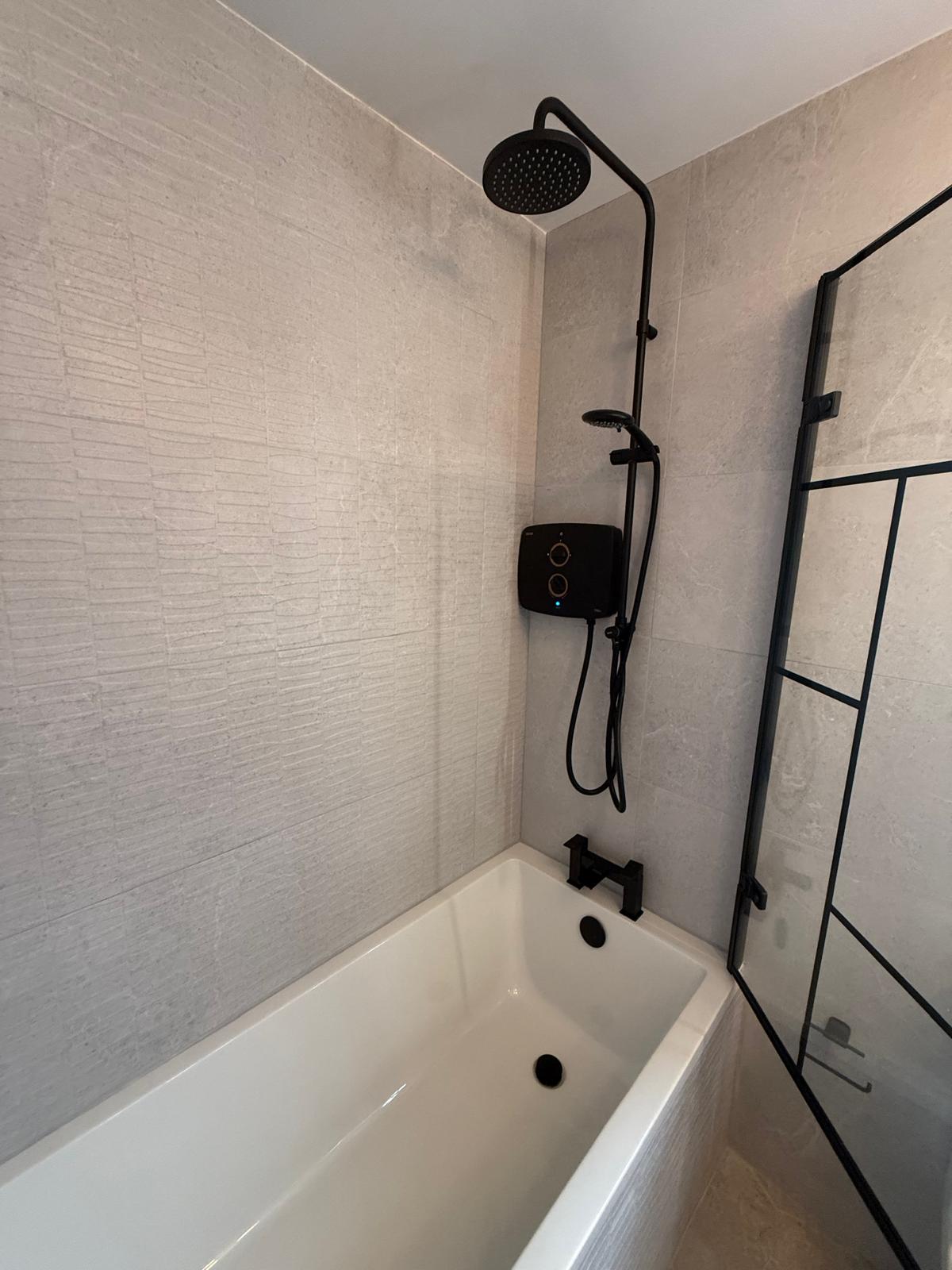 Finished bathroom with stone-look tiling and dark fittings